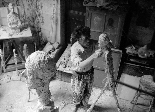 ALBERTO GIACOMETTI Alberto Giacometti travaillant au plâtre  de l'Homme qui marche dans l'atelier, 1959 Ph : Ernst Scheidegger Archives de la Fondation Giacometti © 2021 Stiftung Ernst Scheidegger-Archiv, Zurich